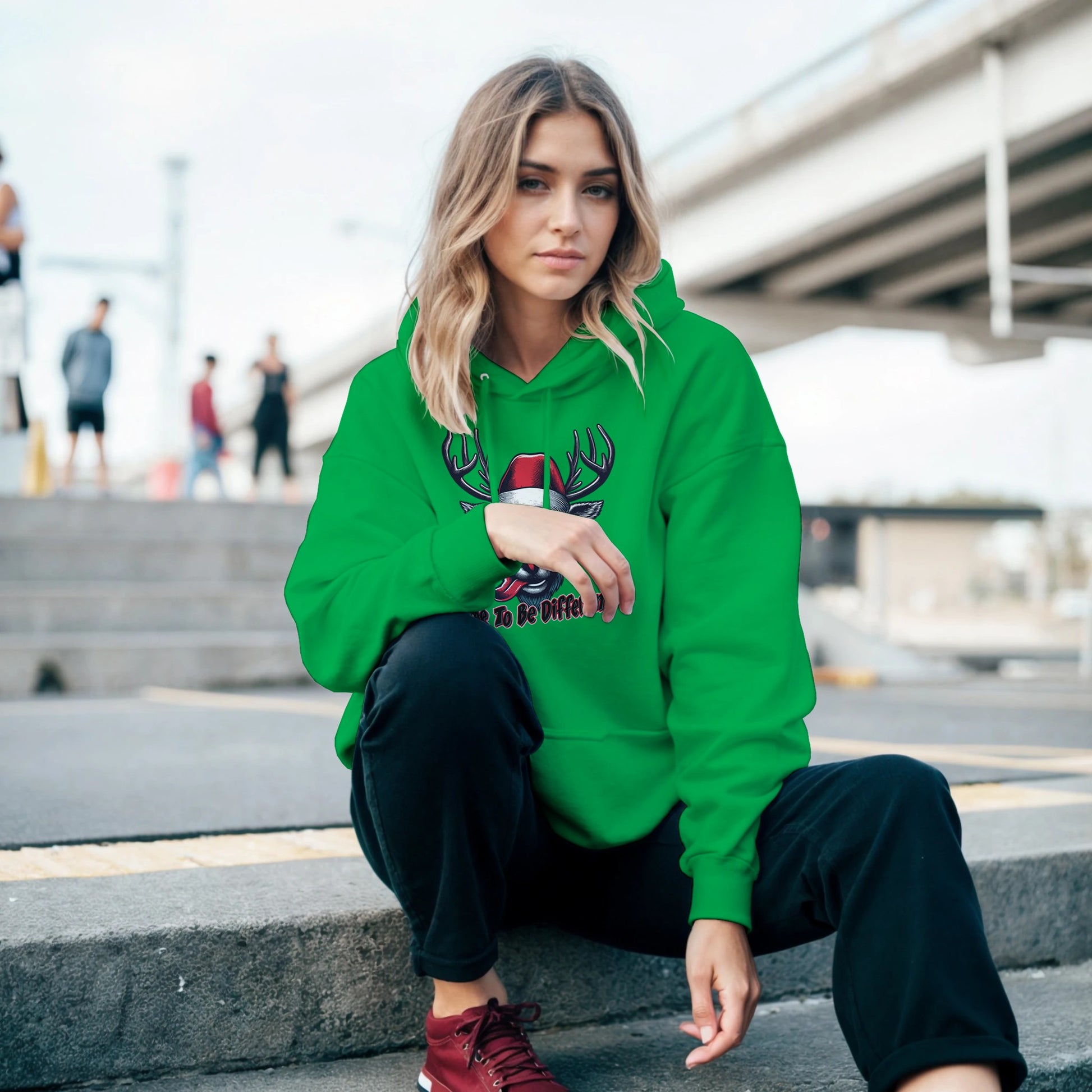 Girl sitting on the stairs in Cool Rudolph Christmas Green  Hoodie with Dare to be different words on it